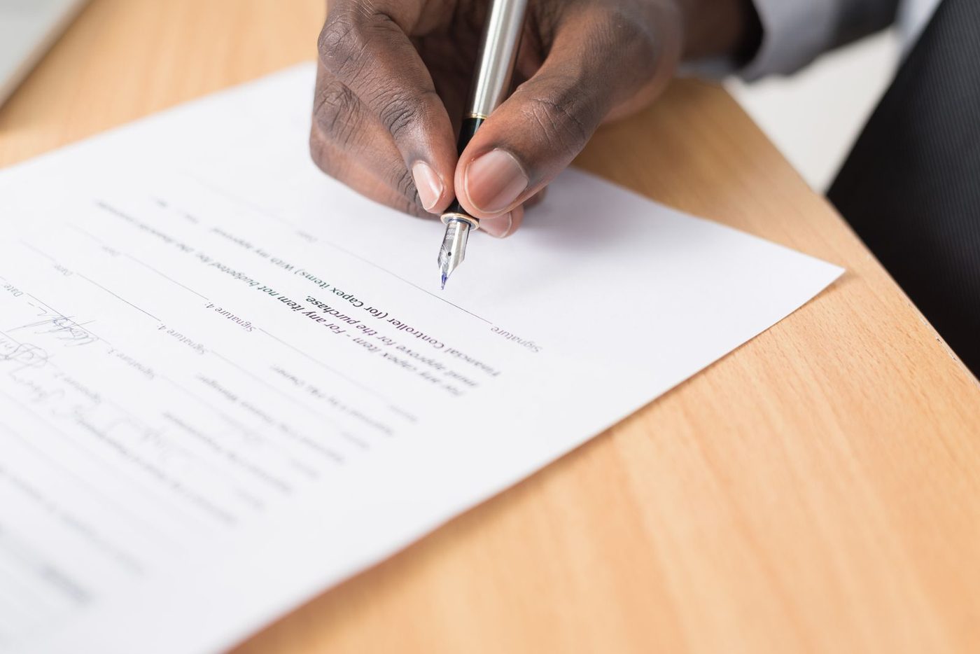 Hand signing a document with a fountain pen